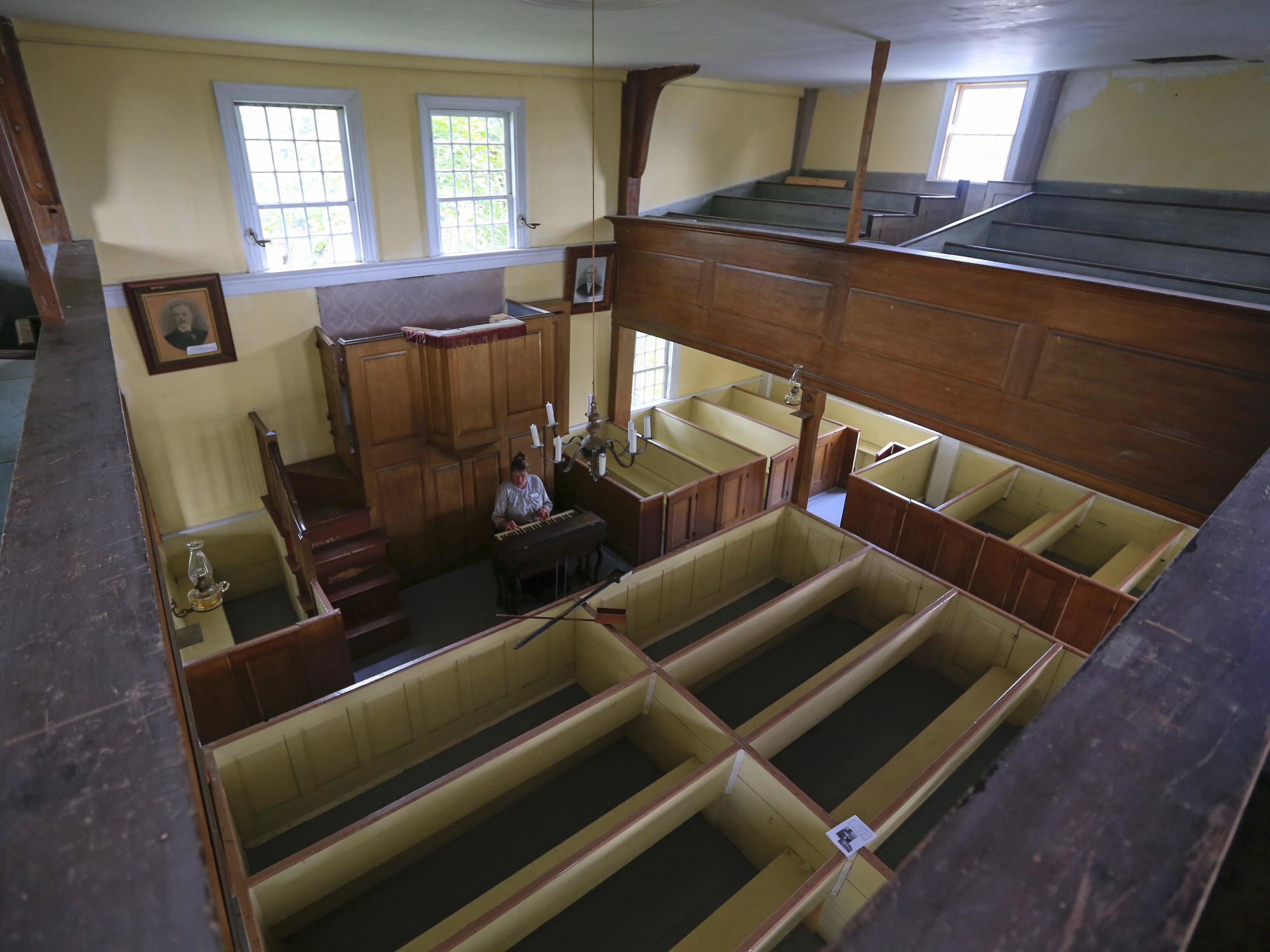 An interior view of a church from a high angle, showing rows of empty pews.